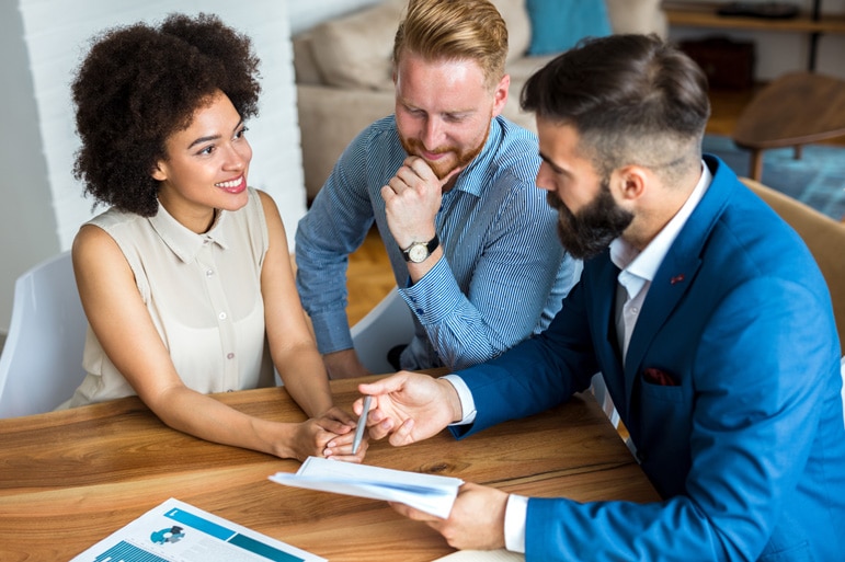 A young couple consulting with a financial planner on how to plan for their money and career.