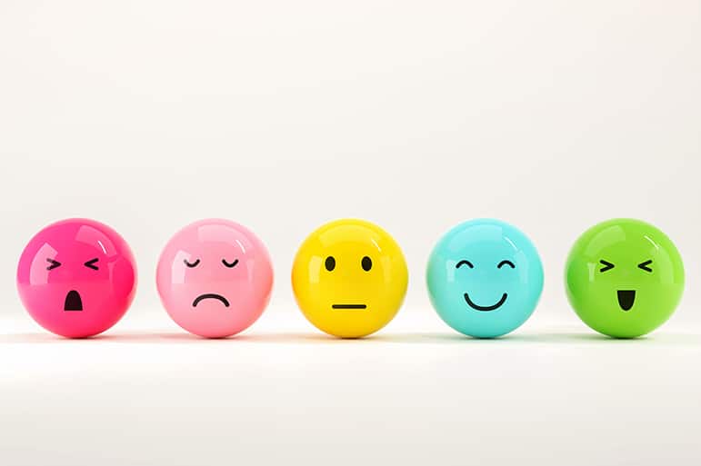 Set of round shiny colorful emoticon balls showing an evolution from sad to happy.