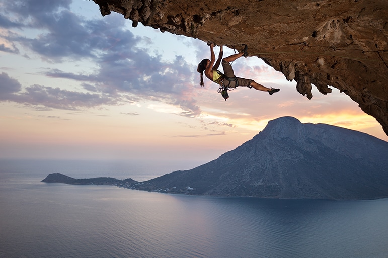 A rock climber clinging to the underside of a rock face illustrates how it is up to each of us to embody the motto "No one will save me."