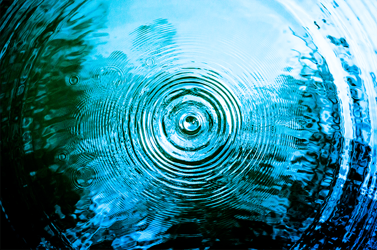 Concentric ripples radiating out in dark blue water