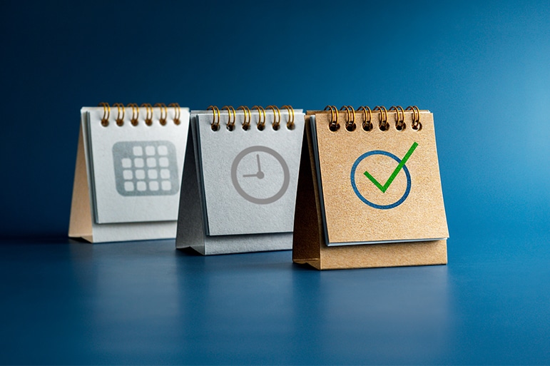 Checked icon, Time and date symbol on three desk calendar covers standing isolated on blue background, minimal style. Reminder, schedule planning, agenda, and action plan concepts.