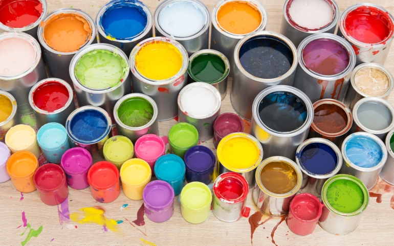 Overhead view of open paint cans in many colors, used as a metaphor for the diversity of experiences one can include on a bucket list.